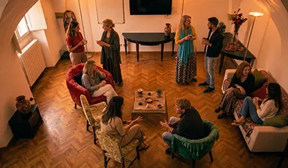 Un gruppo di persone sedute attorno a un tavolo all'interno di una stanzaza nei locali dell'associazione culturale Il Filo di Ermete